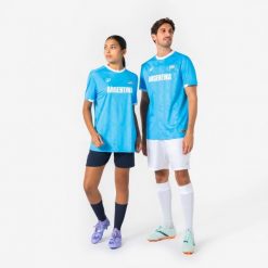 Koszulka piłkarska dla kibiców Argentyna 2026. Białe bluzki damskie KIPSTA, l, bez wzorów, z materiału, sportowe, bez kołnierzyka, bez ramiączek. Za 44.99 zł.