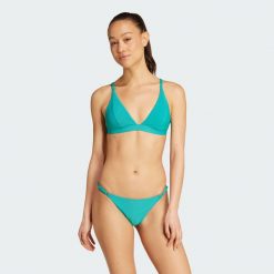 Prążkowana góra bikini Iconisea z wyjmowanymi wkładkami i trójkątnym krojem. Niebieskie stroje kąpielowe damskie Adidas, bez wzorów, prążkowane. Za 179.00 zł.