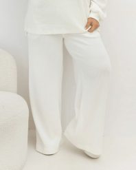 Oversizowe prążkowane spodnie Good Day Ahead na gumce z kieszeniami w kolorze ecru Plus Size Oversize. Białe spodnie dresowe damskie Moda Size Plus Iwanek, bez wzorów, z dresówki, biznesowe, długie. Za 199.90 zł.