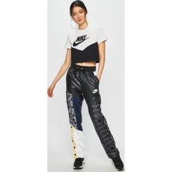 Nike Sportswear - Spodnie. Spodnie materiałowe damskie Nike Sportswear, bez wzorów, z materiału, casualowe. W wyprzedaży za 179.90 zł.