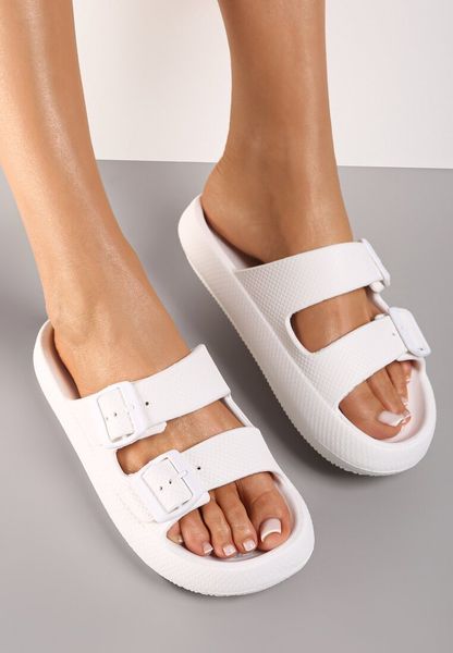 Białe Klapki Phoebaste. Białe klapki damskie Renee, z aplikacjami, z gumy, klasyczne, bez obcasa, na płaskiej podeszwie, bez zapięcia. Za 24.99 zł.