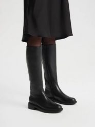 Eleganckie czarne kozaki z wąską cholewką. Czarne kozaki damskie Ryłko, bez wzorów, z gumy, z okrągłym noskiem, bez obcasa, na obcasie, bez zapięcia. Za 699.99 zł.