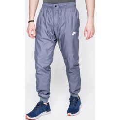 Nike Sportswear - Spodnie. Niebieskie spodnie sportowe męskie Nike Sportswear, l, z aplikacjami, z poliesteru, climacool (adidas). W wyprzedaży za 139.90 zł.