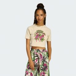 KOSZULKA ADIDAS x FARM RIO GRAPHIC T-SHIRT CROPPED. Białe bluzki damskie Adidas, bez wzorów, sportowe, bez kołnierzyka, bez ramiączek. Za 149.00 zł.