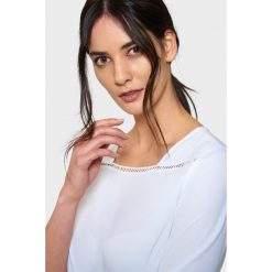 Biała elegancka bluzka z mereżką. Białe bluzki damskie Greenpoint, bez wzorów, z poliesteru, eleganckie, bez kołnierzyka, bez ramiączek. Za 24.99 zł.