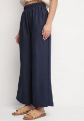 Granatowe Szerokie Spodnie Palazzo z Wysokim Stanem Aranwenna. Niebieskie spodnie materiałowe damskie Born2be, bez wzorów, z jeansu, eleganckie, z podwyższonym stanem. Za 39.99 zł.