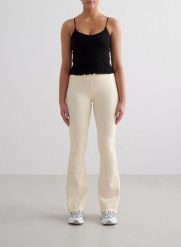Damskie legginsy bezszwowe, wysoki stan, rozszerzane nogawki Tulip kremowe. Białe legginsy damskie Aim'n, bez wzorów, z dzianiny. Za 285.00 zł.