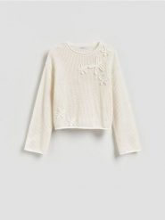Sweter z ozdobną aplikacją - kremowy. Białe swetry nierozpinane damskie Reserved, l, z aplikacjami, z bawełny, bez kołnierzyka, bez ramiączek. Za 119.99 zł.