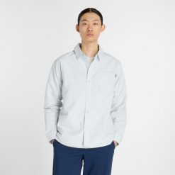 Koszula męska New Balance MT53523FRL – niebieska. Niebieskie koszule męskie New Balance, m, bez wzorów, z bawełny, eleganckie, bez kołnierzyka, bez ramiączek. Za 389.99 zł.