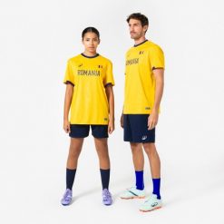 Koszulka piłkarska dla kibiców Rumunia 2026. Brązowe bluzki damskie KIPSTA, m, bez wzorów, z materiału, sportowe, bez kołnierzyka, bez ramiączek. Za 44.99 zł.