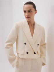 Krótka marynarka - złamana biel. Marynarki i żakiety damskie Reserved, bez wzorów, z tkaniny, bez kołnierzyka, bez ramiączek. Za 229.99 zł.