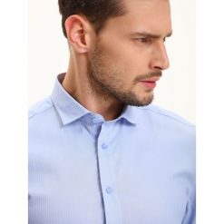 KOSZULA MĘSKA DŁUGI RĘKAW. Niebieskie koszule męskie TOP SECRET, na lato, m, bez wzorów, z bawełny, eleganckie, bez kołnierzyka, bez ramiączek. W wyprzedaży za 39.99 zł.