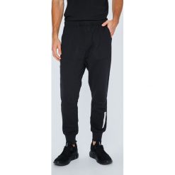 Adidas Originals - Spodnie. Czarne spodnie materiałowe męskie adidas Originals, bez wzorów, z bawełny, z obniżonym stanem. W wyprzedaży za 279.90 zł.