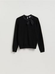 Sweter z ozdobną kokardą - czarny. Czarne swetry nierozpinane damskie Reserved, l, bez wzorów, z dzianiny, bez kołnierzyka, bez ramiączek. Za 109.99 zł.