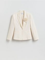 Marynarka z broszką - kremowy. Białe marynarki i żakiety damskie Reserved, bez wzorów, z tkaniny, bez kołnierzyka, bez ramiączek. Za 299.99 zł.