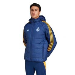 Kurtka puchowa Real Madrid Tiro 2024/25 Club. Brązowe kurtki męskie Adidas, bez wzorów, z puchu, sportowe, bez kaptura. W wyprzedaży za 477.25 zł.