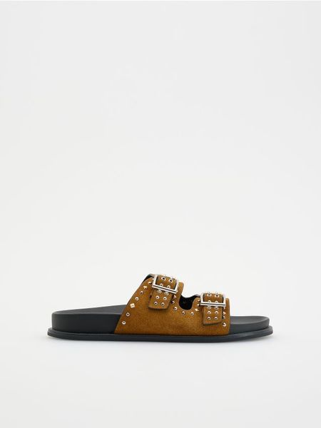 Zamszowe klapki z okuciami - brązowy. Brązowe klapki damskie Reserved, bez wzorów, z zamszu, bez obcasa, bez zapięcia. W wyprzedaży za 49.99 zł.