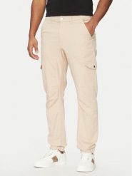 Guess Spodnie materiałowe M5RB54 WGXY1 Beżowy Slim Fit. Brązowe spodnie materiałowe męskie Guess, z aplikacjami, z bawełny. Za 289.99 zł.