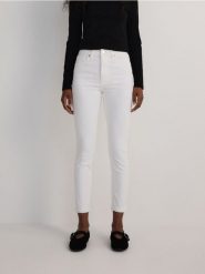 Jeansy slim fit mid rise - biały. Białe jeansy damskie Reserved, bez wzorów, z bawełny. W wyprzedaży za 79.99 zł.