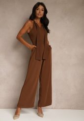 Brązowy Kombinezon Wide Leg z Ozdobnym Wiązaniem przy Szyi Silelia. Brązowe sukienki damskie Renee, na co dzień, l, bez wzorów, eleganckie, bez kołnierzyka, bez ramiączek, kopertowe. Za 99.99 zł.