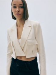 Krótka marynarka z dodatkiem lnu - kremowy. Białe marynarki i żakiety damskie Reserved, bez wzorów, z tkaniny, bez kołnierzyka, bez ramiączek. W wyprzedaży za 99.99 zł.