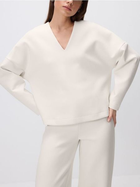 Bluza z dekoltem V - kremowy. Białe bluzy damskie Reserved, l, bez wzorów, z bawełny, bez ramiączek, bez kaptura. W wyprzedaży za 49.99 zł.