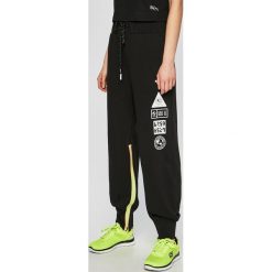 Puma - Spodnie x SG. Czarne spodnie dresowe damskie Puma, bez wzorów, z bawełny. W wyprzedaży za 229.90 zł.