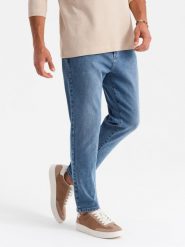 Męskie jeansowe spodnie CARROT FIT z delikatnymi przetarciami – niebieskie V1 OM-PADP-0162 - XL. Niebieskie spodnie materiałowe męskie Ombre Clothing, z aplikacjami, z bawełny. Za 119.99 zł.