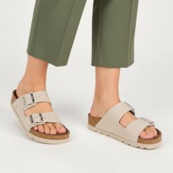 Klapki Damskie Rieker, cholewka skóra naturalna gładka dwa szerokie paski z metalowymi klamrami odkryte palce regulowane zapięcie. Szare klapki damskie Rieker, bez wzorów, ze skóry, bez obcasa, bez zapięcia. Za 299.00 zł.