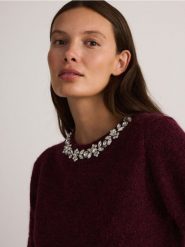 Sweter z biżuteryjną aplikacją - bordowy. Czerwone swetry nierozpinane damskie Reserved, l, z aplikacjami, z dzianiny, bez kołnierzyka, bez ramiączek. W wyprzedaży za 119.99 zł.