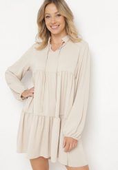 Beżowa Rozkloszowana Sukienka z Falbanką Uxaria. Brązowe sukienki damskie Born2be, uniwersalny, z aplikacjami, eleganckie, bez kołnierzyka, bez ramiączek, mini, rozkloszowane. Za 99.99 zł.