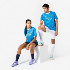 Koszulka piłkarska Włochy 2026 dla kibiców. Białe bluzki damskie KIPSTA, m, bez wzorów, z materiału, sportowe, bez kołnierzyka, bez ramiączek. Za 44.99 zł.