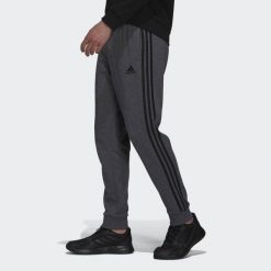 Spodnie męskie adidas Essentials Tapered Cuff 3 Stripes. Czarne spodnie materiałowe męskie Adidas, m, bez wzorów, z polaru, na jogę i pilates. Za 179.99 zł.