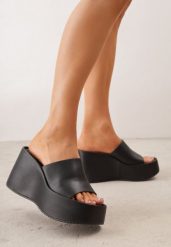 Czarne Klapki w Stylu Casual na Platformie z Koturnem Penoris. Czarne klapki damskie Born2be, na lato, bez wzorów, z jeansu, casualowe, bez obcasa, na koturnie, bez zapięcia. Za 119.99 zł.