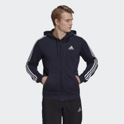 Bluza dresowa męska adidas ESSENTIAL 3 STRIPES. Białe bluzy męskie Adidas, m, bez wzorów, z dresówki, z kapturem, na fitness i siłownię. Za 213.00 zł.