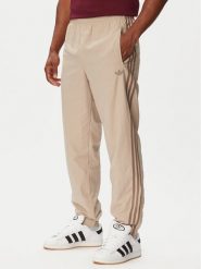 Adidas Spodnie dresowe Firebird KS7503 Beżowy Regular Fit. Brązowe spodnie dresowe damskie Adidas, bez wzorów, z dresówki. Za 299.99 zł.