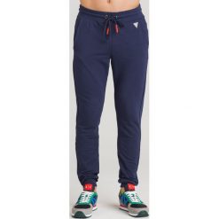 SPODNIE DRESOWE GUESS. Niebieskie spodnie sportowe męskie Guess, l, z aplikacjami, z bawełny. Za 185.00 zł.