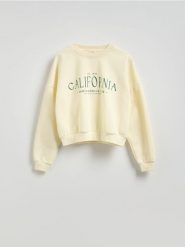 Bluza oversize z nadrukiem - kremowy. Białe bluzy damskie Reserved, l, bez wzorów, z bawełny, bez ramiączek, bez kaptura. W wyprzedaży za 49.99 zł.