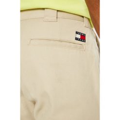 Tommy Jeans - Spodnie 90S. Białe eleganckie spodnie męskie Tommy Jeans, bez wzorów, z bawełny, casualowe. W wyprzedaży za 199.90 zł.