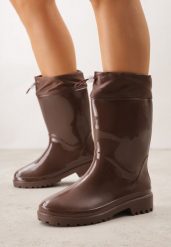 Brązowe Lakierowane Kalosze ze Ściąganą Cholewką Fevaselle. Brązowe kalosze damskie Born2be, bez wzorów, z jeansu, bez zapięcia. Za 79.99 zł.