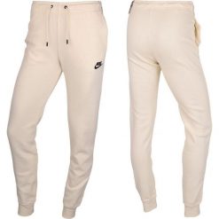Spodnie Sportowe damskie Nike. Brązowe spodnie dresowe damskie Nike, bez wzorów, sportowe, długie. Za 239.71 zł.