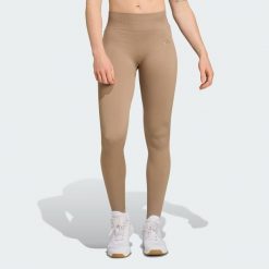 Długie dzianinowe legginsy do ćwiczeń Essentials. Brązowe legginsy damskie Adidas, bez wzorów, z dzianiny. Za 225.55 zł.