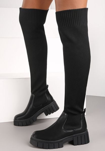 Czarne Kozaki z Elastyczną Cholewką Brygoros. Czarne kozaki damskie Renee, z aplikacjami, prążkowane, przed kolano, bez obcasa, na płaskiej podeszwie, bez zapięcia. Za 169.99 zł.