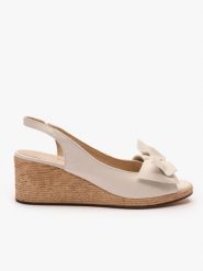 Kremowe sandały na koturnie z kokardą. Brązowe sandały damskie Ryłko, bez wzorów, ze skóry, z okrągłym noskiem, bez obcasa, na koturnie, bez zapięcia. Za 399.99 zł.