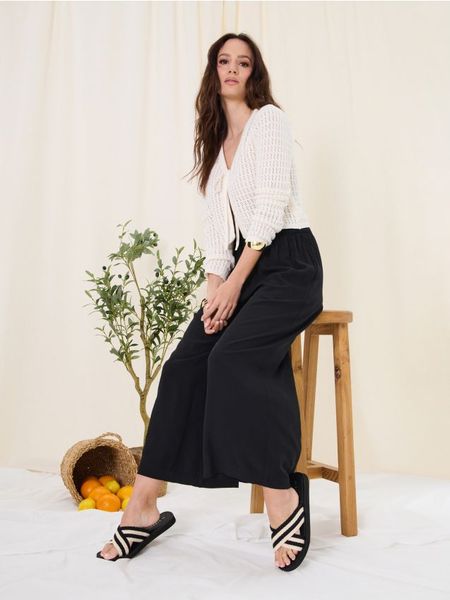 Klapki z materiałowymi paskami - czarny. Czarne klapki damskie Sinsay, bez wzorów, z materiału, bez obcasa, bez zapięcia. Za 25.99 zł.