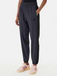 Adidas Spodnie dresowe Train Essentials 3-Stripes Woven KC5496 Czarny Regular Fit. Czarne spodnie dresowe damskie Adidas, bez wzorów, z dresówki, sportowe, na fitness i siłownię. Za 219.99 zł.