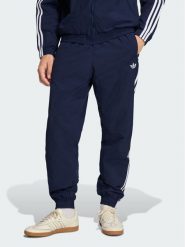 Adidas Spodnie dresowe Firebird Woven KE1370 Granatowy Regular Fit. Niebieskie spodnie sportowe męskie Adidas, l, bez wzorów, z dresówki. Za 298.99 zł.