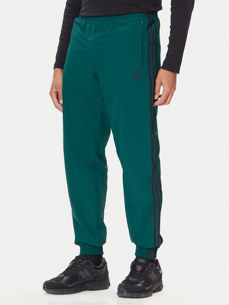 Adidas Spodnie dresowe adicolor Woven Firebird JY1335 Zielony Regular Fit. Zielone spodnie sportowe męskie Adidas, m, bez wzorów, z dresówki. Za 189.99 zł.