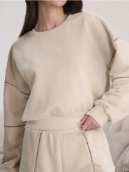Bluza z ażurowymi detalami - kremowy. Białe bluzy damskie Sinsay, l, w ażurowe wzory, bez ramiączek, bez kaptura. W wyprzedaży za 24.99 zł.