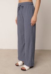 Niebieskie Szerokie Spodnie z Teksturalnej Tkaniny z Wiązaniem w Pasie Agatia. Niebieskie spodnie materiałowe damskie Born2be, bez wzorów, z jeansu, biznesowe, z podwyższonym stanem, długie. Za 59.99 zł.